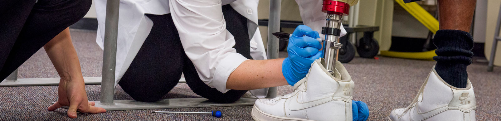 A woman draws a line with a marker on a float-left leg prosthetic